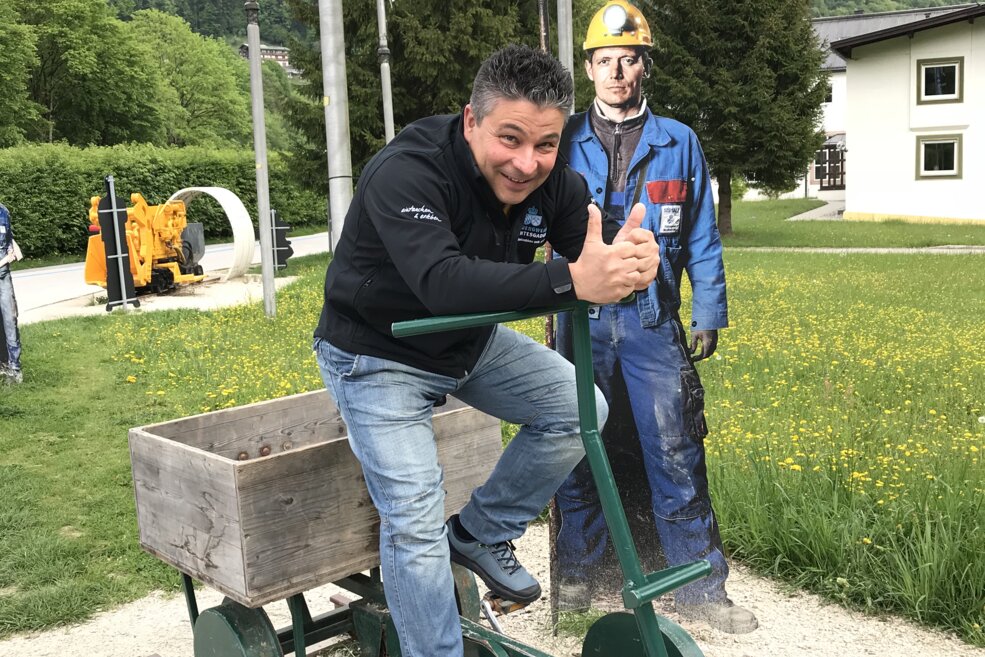 Besucher mit Grubenrad vor Salzbergwerk