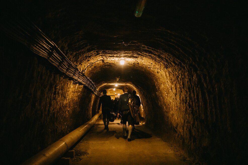 Blechbläser gehen durch den Salzbergwerk-Stollen