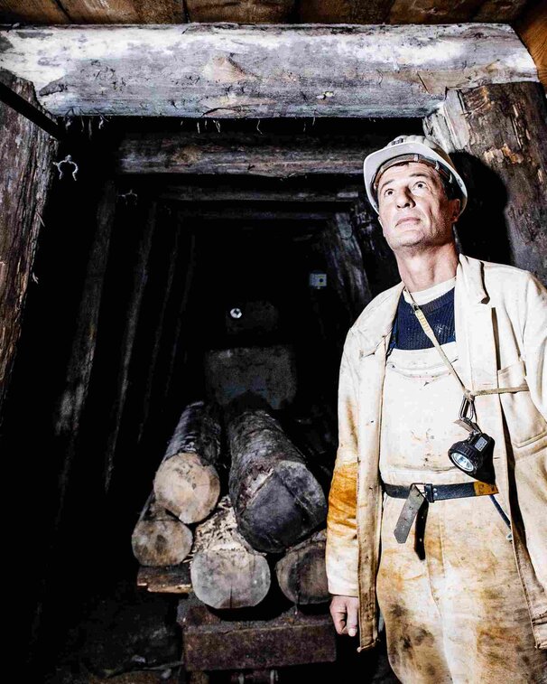Bergmann inspiziert Decke im Stollen des Salzbergwerk Berchtesgaden