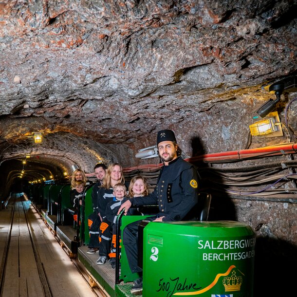 Führer mit Familie auf Grubenbahn im Salzbergwerk 