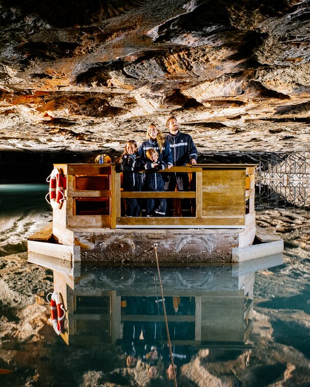 Familie fährt mit Floß über Spiegelsee im Salzbergwerk