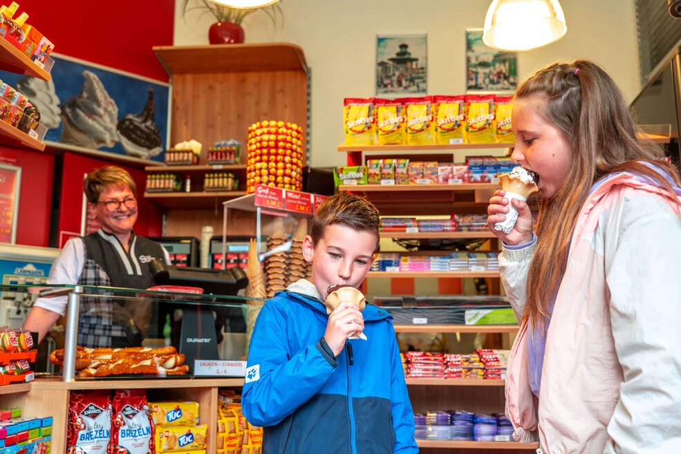 Kinder essen ein Eis im Kiosk