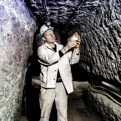 Miner examining salt stone
