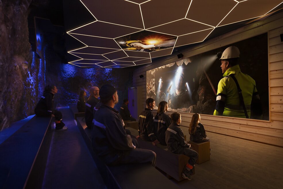 Audience in front of the screen at a movie theater with ceiling projection