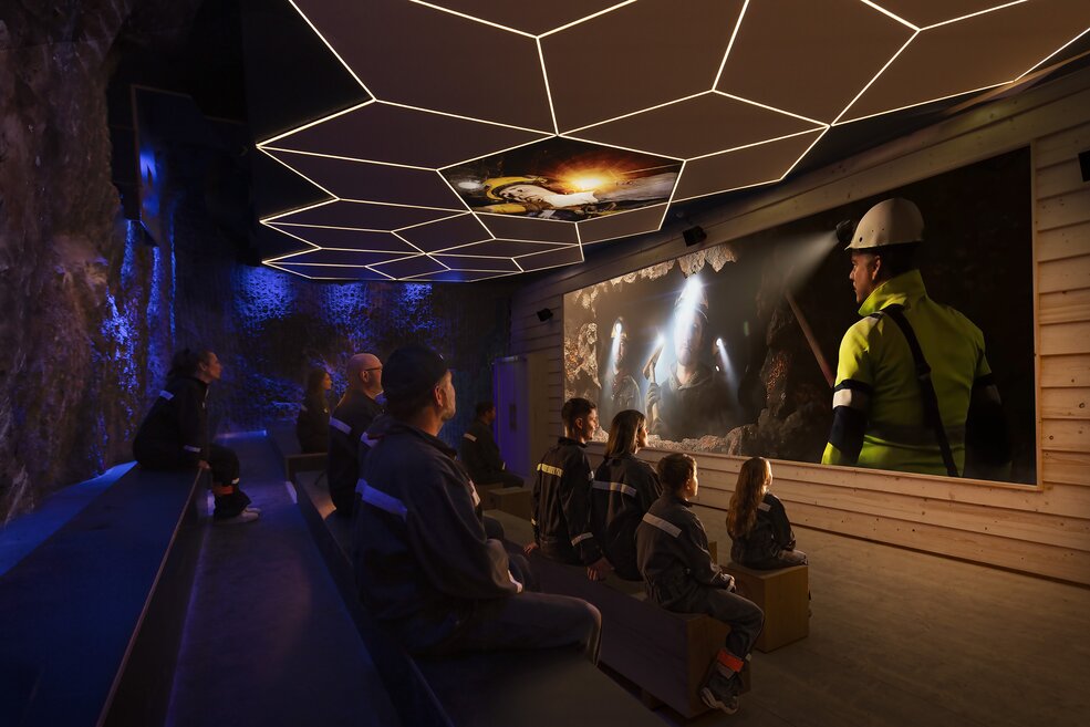 Audience in front of the screen at a movie theater with ceiling projection